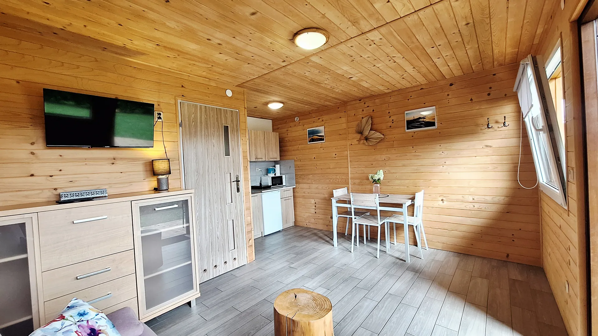 Klimatyczne drewniane wnętrze domku w Bieszczadach z nastrojowym oświetleniem i telewizorem